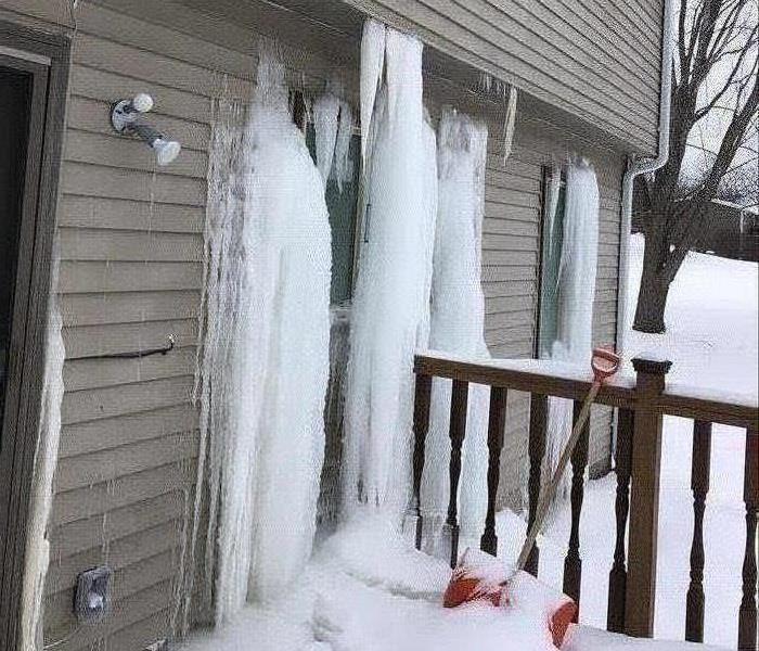 Frozen water against siding of a house